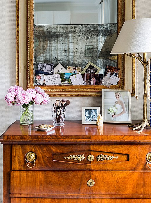 A Biedermeier chest with a fold-down drawer serves as CeCe’s bedroom vanity. She tucks personal mementos and photographs into the mirror above: “Just little things that make me happy.”
