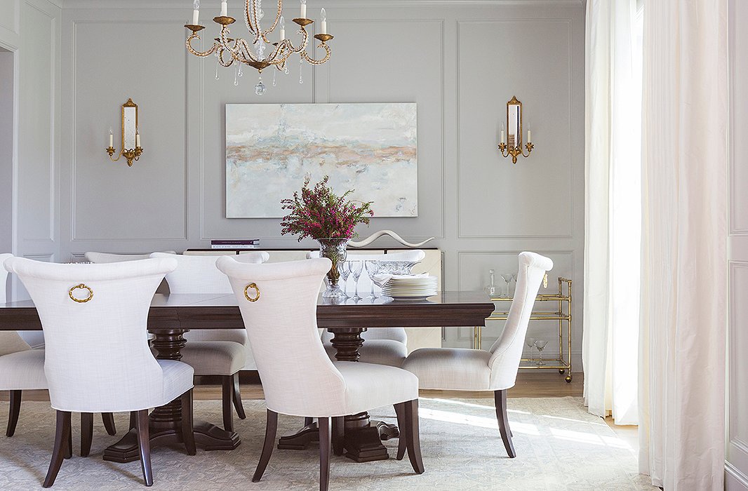 Paneled wall moldings and brass fixtures give the formal dining room a sense of grandeur. Photo by Julie Soefer.
