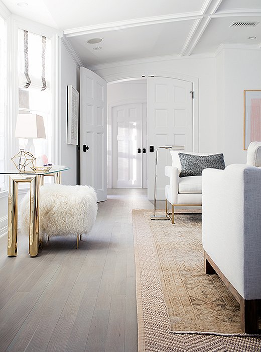 Erin loved the effect of the patterned sisal rug layered under an antique Oushak: “The rugs did a great job of grabbing the cool and the warm tones in the room, the gray highlights and the oatmeal lowlights. It creates this perfect base for everything.”
