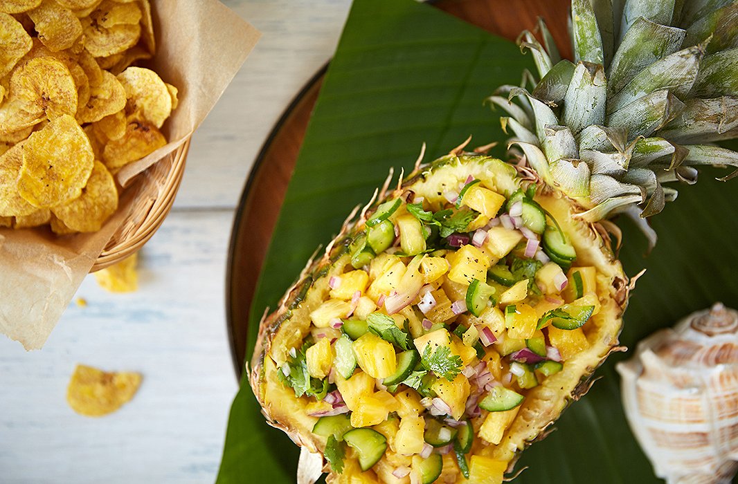 Scooped, then served, the pineapple becomes both the meal and the serving dish, popping against a sheath of a banana leaf and a wood tray. 
