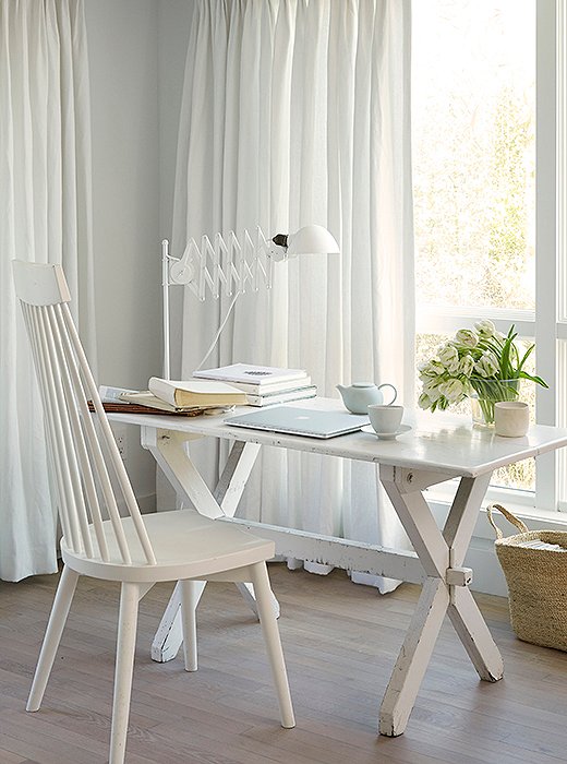 In a bedroom corner, an X-frame desk painted in white enamel is the ideal spot to write a note or take a call.
