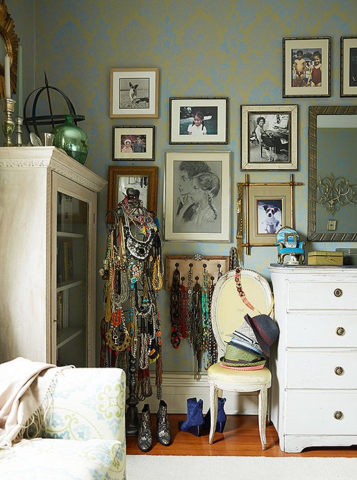 A wall of family photographs and art Sheila made when she was a child sets a personal note in the bedroom. A mannequin displays her collection of jewelry and antique bags from her grandmother.
