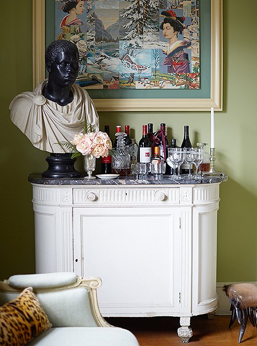 A perfectly Sheila vignette: A framed piece of outsider art hangs above a classical bust on the bar.

