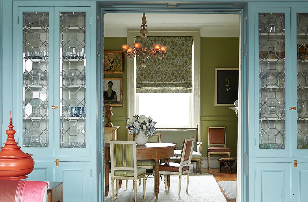 An apple-green dining room plays nicely with adjacent blue-painted cabinets in the Harlem home of designer Sheila Bridges. Photo by Manuel Rodriguez.
