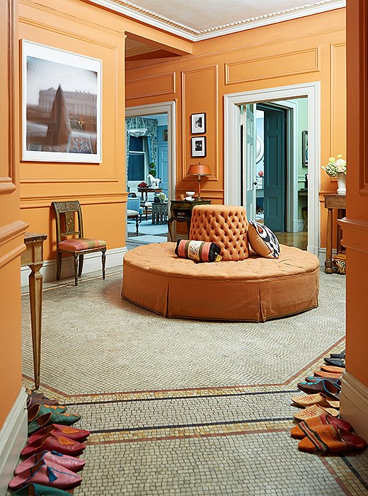 To mirror the orange tiles, Sheila placed an orange borne in the center of her entryway. In the foreground sit the Moroccan slippers that everyone wears inside.

