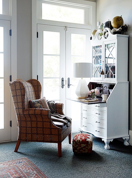 The master bedroom, with French doors that open out to the lake, is large enough to accommodate a sitting area. “You can hole up there for quite a while,” Barbara says. The beautiful white chest is an antique from her husband’s grandmother. “It was mahogany, and I painted it. Nothing against mahogany—it just didn’t work in there.”
