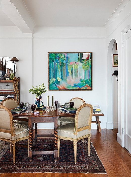 A drop-leaf table with spindle legs is centered on top of a vintage rug. Secondhand French chairs upholstered in tattered silk were the perfect size for the small space. “Our home is a mix of styles,” says Matt, “and it’s materialized in a very organic way—everything works, but nothing was planned.”
