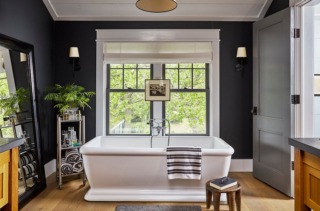 Keep shampoo and extra towels nearby with a bar cart you can pull alongside your tub. Room by T.R. Pescod; photo by Cheng Lin.
