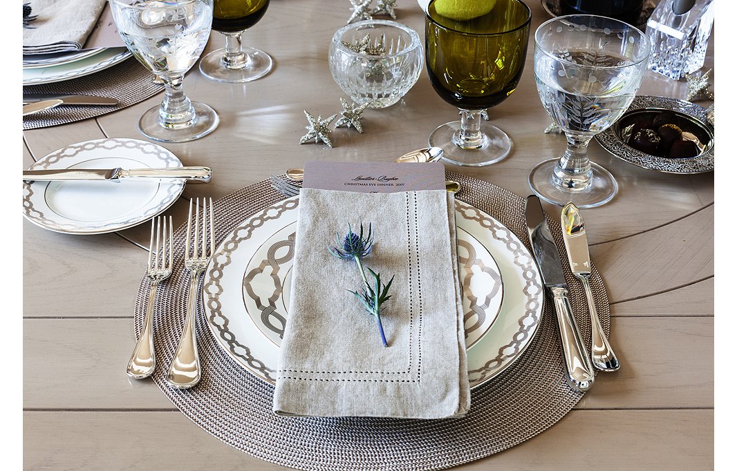 Set a luxurious scene with silvery designs and etched glassware. A few colorful touches—such as a fresh flower and hunter-green drinkware—keep it interesting.
