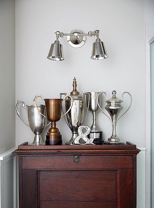 A grouping of trophies—and, okay, a busted $4 coffeepot—makes for an unexpected vignette, especially in a powder room. “I just put them together,” says Barbara, who tried using actual family trophies (her daughter is a world-class swimmer) before determining that they didn’t look right. “These are more like loving cups,” she says.
