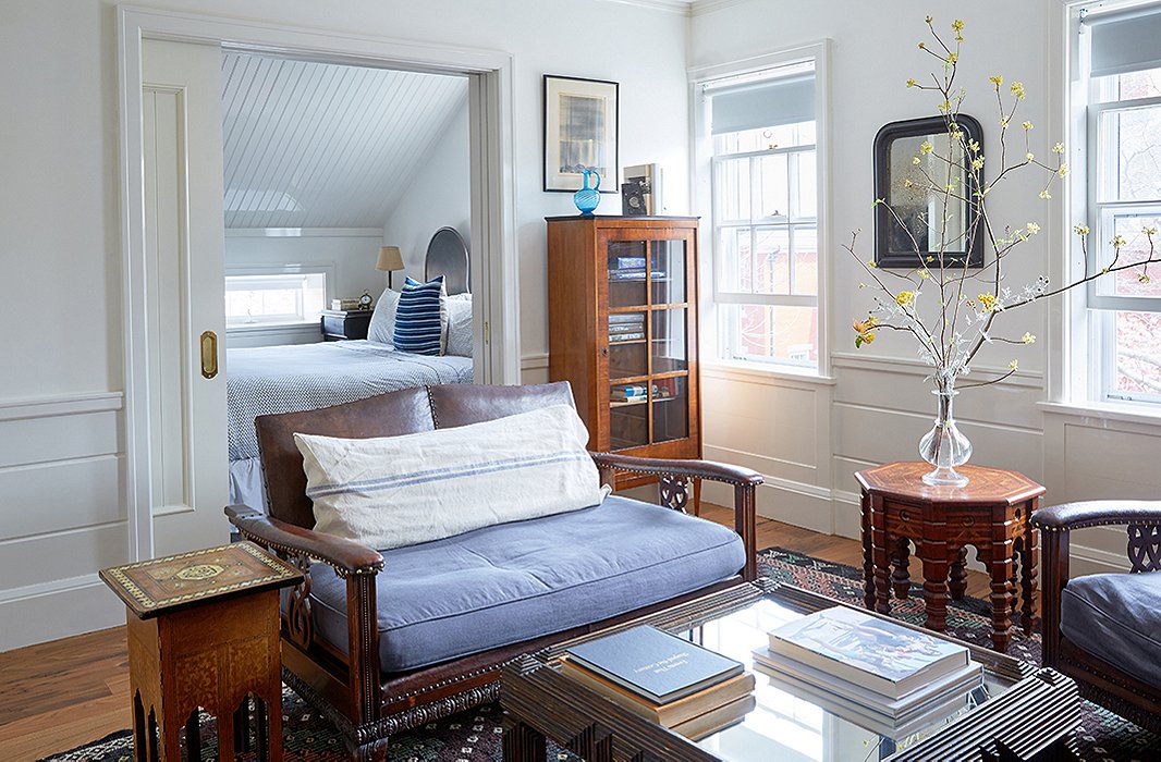 Rooms feature wood paneling in varying widths, adding character and helping to blend the old and new structures seamlessly. Here, a seating area in one of the hotel’s two suites features a medley of American and Middle Eastern antiques.
