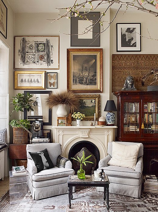 Aged to perfection: Ten or so years ago, Michael painted the living room walls in a mixture of two shades of white, which have since turned a color just shy of ecru. The club chairs flanking the fireplace were a gift from a friend in the 1990s; he periodically reupholsters them in the same black-and-white ticking. 
