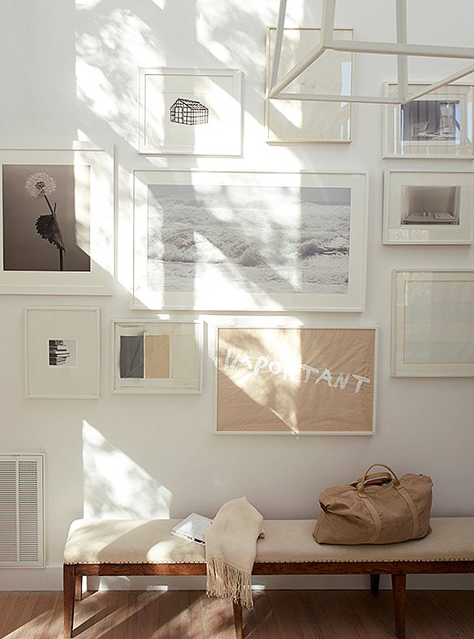 A two-story gallery wall greets visitors downstairs. The sheath of brown paper that reads “Important” was painted by friend and artist Maya Schindler, who tipped Foley off that the house was for sale.
