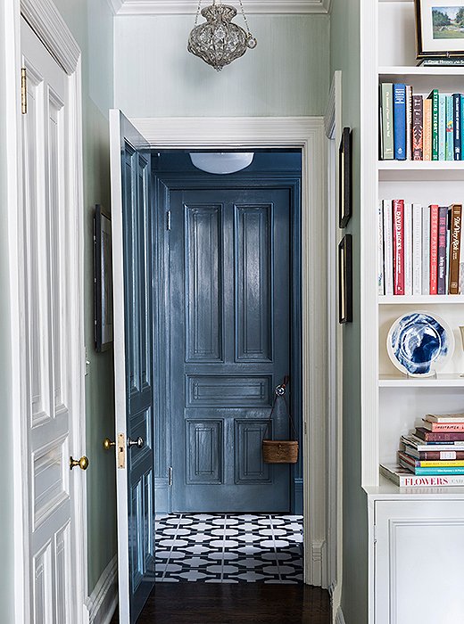 A palette of calming blues runs throughout the apartment, from the living room’s pale sky walls to the patterned tiles and slate-tone woodwork off the kitchen.
