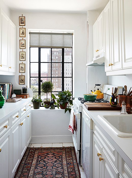 Simple, clean, and to the point, the apartment’s galley kitchen was personalized with brass knobs, artwork, and a Persian runner.
