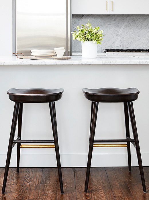 Brass details on two barstools by Brownstone provide a pleasant contrast to the kitchen’s stainless-steel finishes. “Even without a back, they’re probably the most comfortable I’ve ever sat in,” Sally says. 
