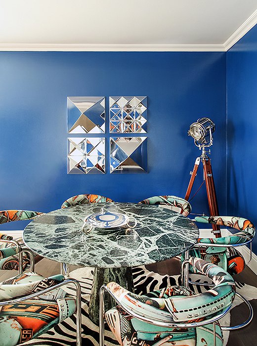 In the game room, a green marble table surrounded by vintage chairs upholstered in Gaultier fabric add edge and whimsy. Cerulean walls might seem a contemporary choice, but the blue hue is actually “a classic color inspired by traditional Americana,” Sasha says. The color is yet another example of how to temper a glamorous space with a reference to something old in a sea of things new. Find a similar floor lamp here.

