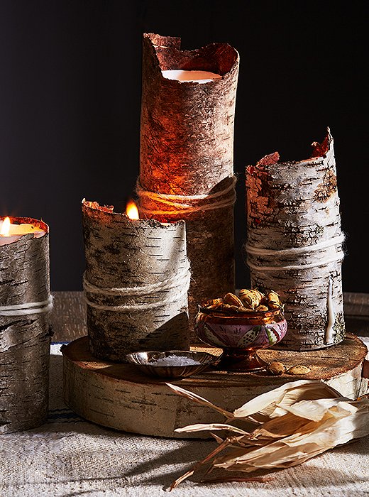 A white pillar candle, birch-bark sheets, and a piece of yarn are all you need to bring a rustic glow to your table. 
