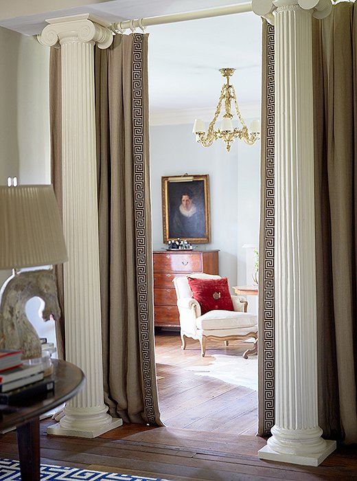 Ionic columns and custom drapes shield the guest room from visiting eyes. “We wanted the home to feel as open as possible,” says Dale, “so we decided not to close the space off with a wall and used fabric instead.” Such a decision maintains spatial flow and also allows the bedroom’s natural light to flood the windowless foyer. 
