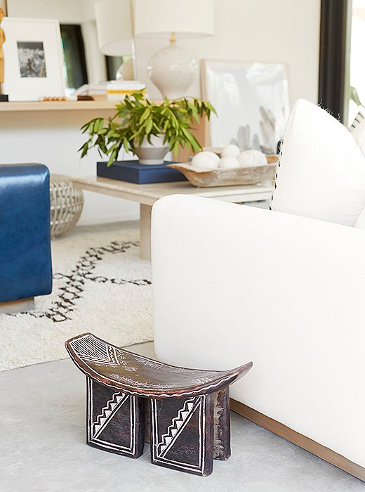 Accents such as a vintage African stool add warmth to the room’s cement floors. 
