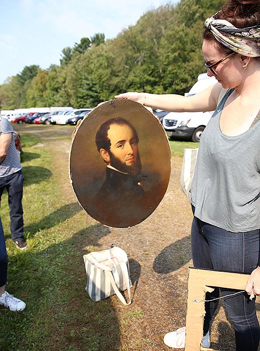 Erika Engstrom takes a closer look at an oil painting the team nabbed before stashing it in the One Kings Lane van. Photo by Taylor Swaim.
