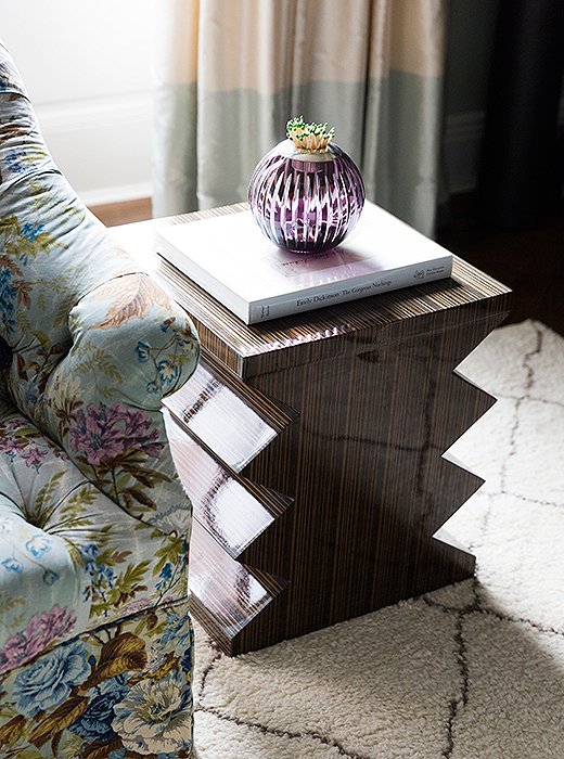 A graphic accent table gives some edge to a floral-patterned armchair in CeCe’s living room, while a Moroccan-style rug lends rich textural contrast.
