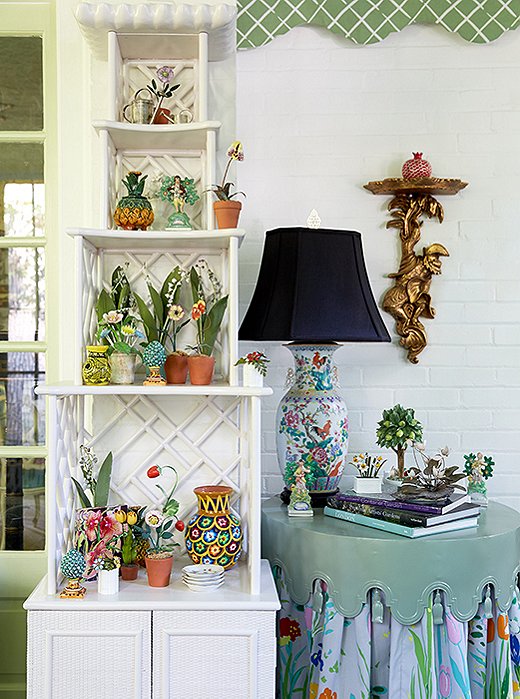 A scene from the duos North Carolina Home: Artistic touches of color and craft by way of sculptured florals, Chinese porcelain, and a scalloped tabletop.
