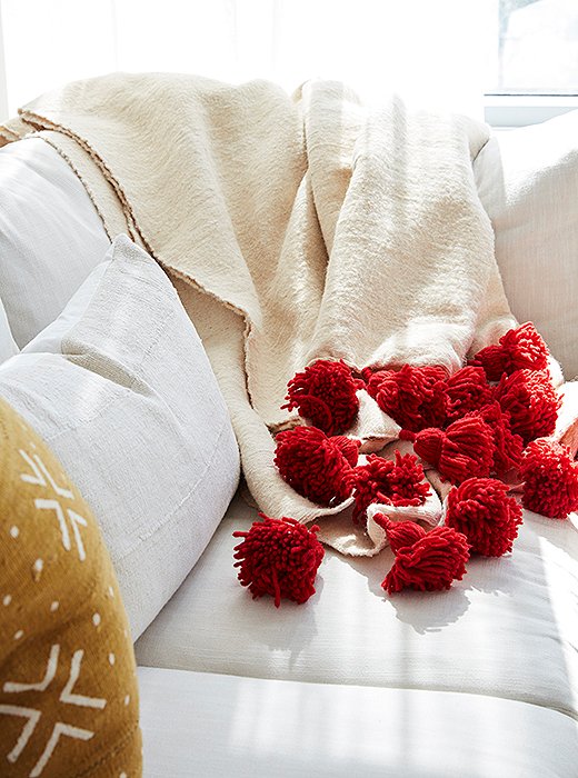 A tasseled throw adds texture and vibrancy to a neutral base. 
