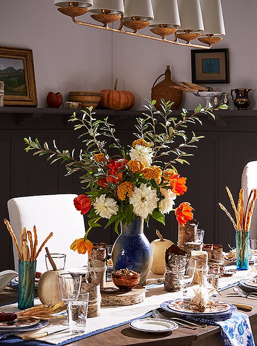 White dahlias, orange parrot tulips, ocher coxcombs, and a seasonal branch make up this lush, towering look. Photo by Cheng Lin; styled by Michelle Wong. 
