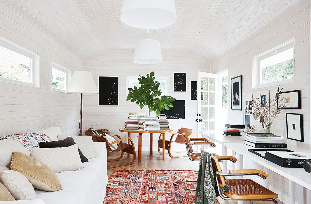 What was once a gray space with limited light was transformed into a loftlike studio. Toward the rear, a round Alvar Aalto table matches the tone of the Breuer desk chairs and keeps stacks of coffee table books at the ready. 
