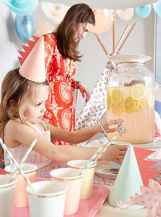 A pretty drink dispenser lets older partygoers help themselves. Recyclable paper cups and straws keep the palette consistent (and make for easy cleanup). 
