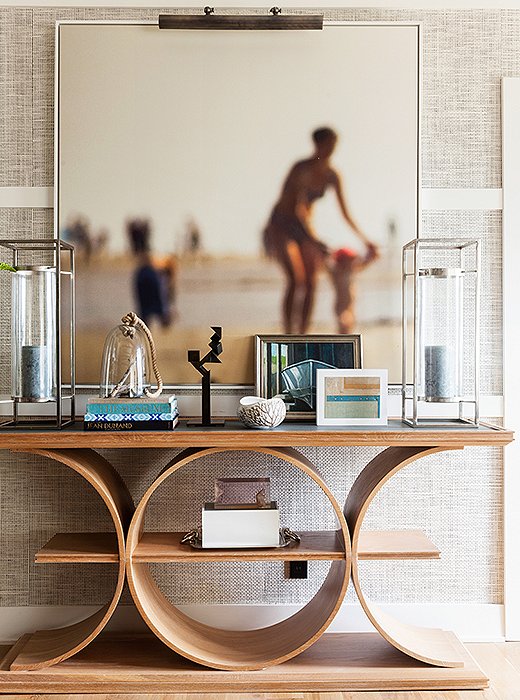 Here, a geometric bentwood console brings an unexpected architectural element to a neutral-hued space. Photo by Lesley Unruh. 
