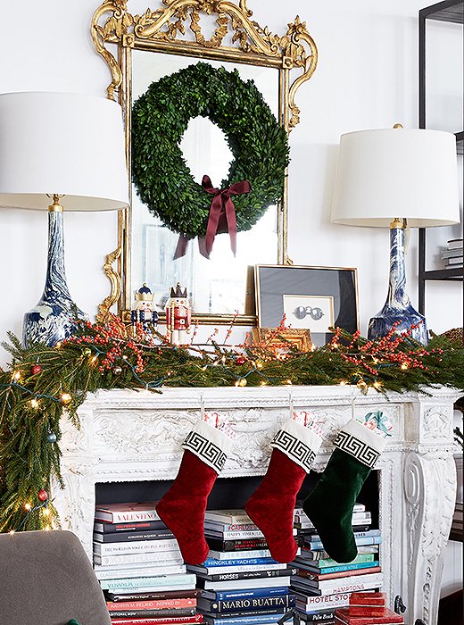 A pair of marbleized lamps feel decidedly daring on the classic Christmas mantel, contrasting nicely with the traditional gilded mirror and beribboned boxwood wreath.
