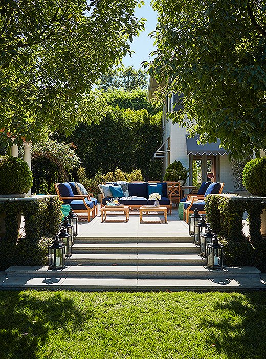 Stairs lead to a lawn separating the pool from the terrace. 
