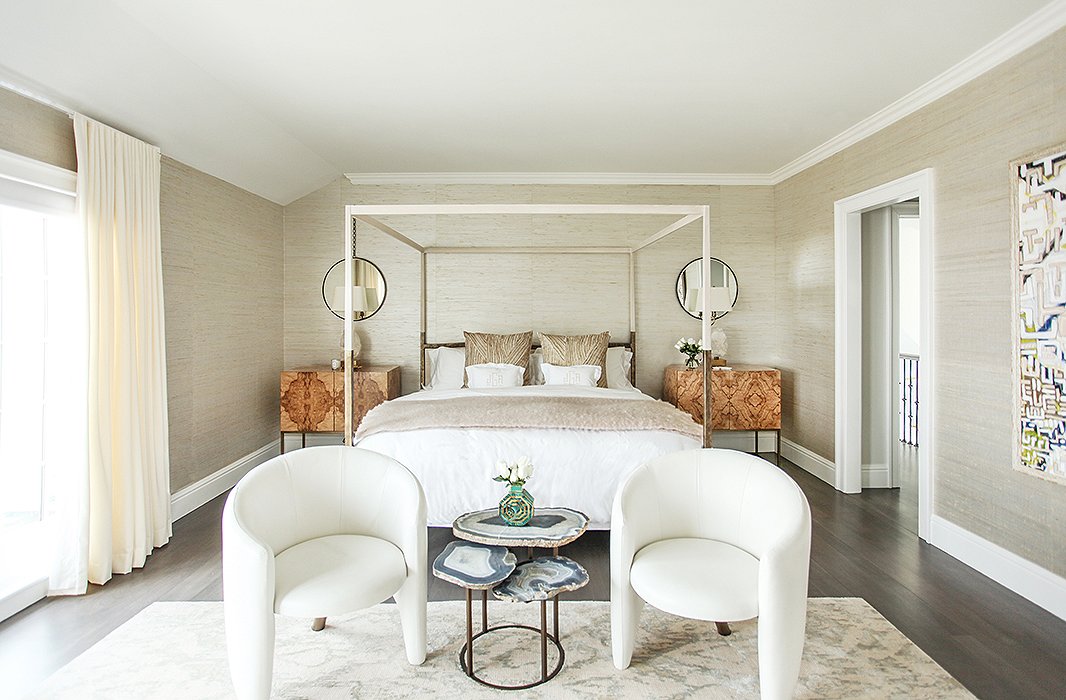 Upstairs, the master bedroom’s neutral palette, similar to that of a birch tree, creates a calm space perfect for rest and relaxation. On the walls, raffia wallpaper from Ralph Lauren adds texture and depth without detracting from the room’s statement pieces. 
