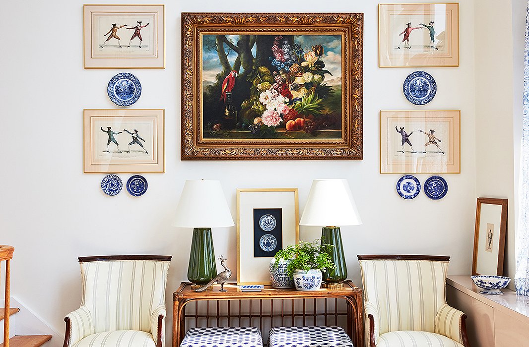 The team from One Kings Lane Interior Design helped Stephanie create the perfect gallery wall by flanking a large painting with framed prints and delft plates. A pair of ceramic lamps by Bunny Williams Home plays up the symmetry.

