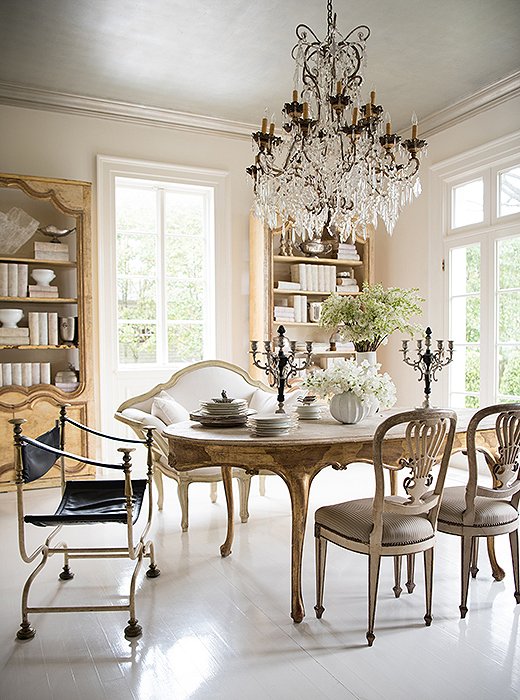 Tara found a boiserie (sculptured paneling) in a house near Versailles and repurposed it as a bookcase in her dining room. The bench and the candelabras (based on a pair Tara found in Lyon) come from Tara Shaw Maison. A midcentury chair ensures the room “doesn’t feel dated.”
