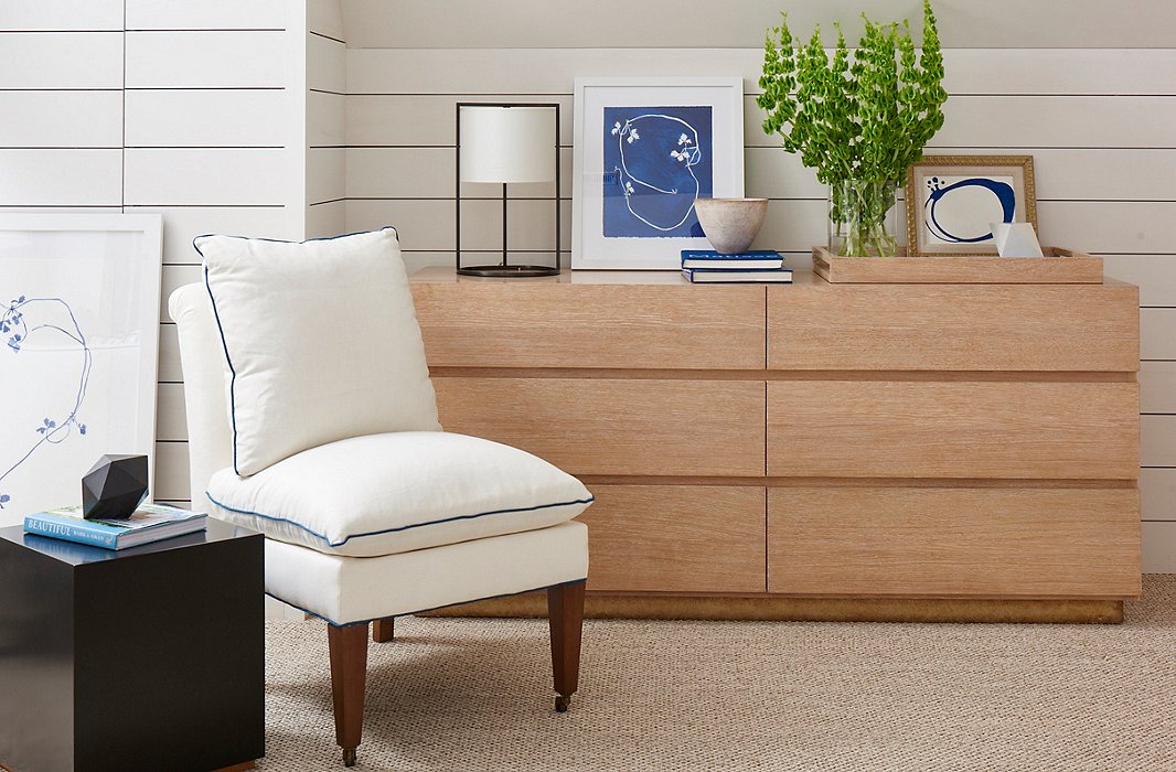 The cerused-oak Santa Monica Dresser and linen-upholstered Loring Slipper Chair, both by Mark D. Sikes for Henredon.
