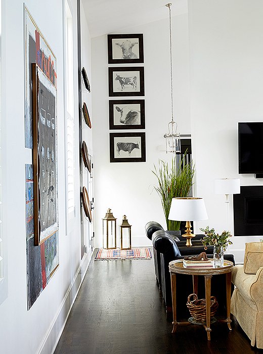 Barbara was clever with her placement of art in the living room, which finds vintage plates mingling with framed black-and-white animal prints. “When I hung the prints, I knew I wanted the view of the lake to be what people saw, so I put the pictures way up high so that you aren’t really aware of them when you walk in.”
