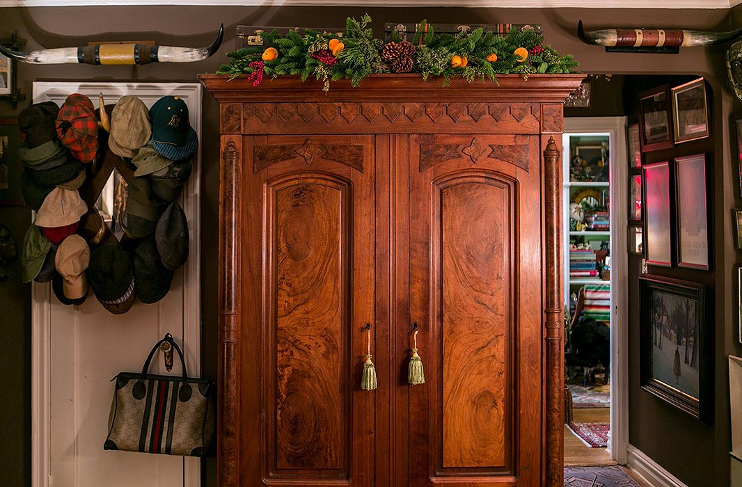 “One of my favorite things to do at the holidays is bring the outside inside,” Bob writes. Atop an antique armoire, a garland of evergreen branches, pinecones, and citrus forms an organic counterpoint to all the vintage glitz and glimmer.
