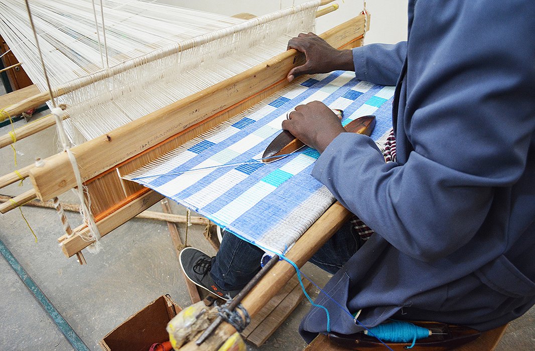 One of Bolé Road’s artisans in Ethiopia weaves together fibers to create fabric for a pillow. Photo courtesy of Bolé Road.
