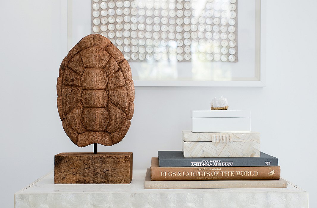 A piece of dried barn wood, carved to resemble a tortoiseshell, creates the right exclamation point on a bar cart.
