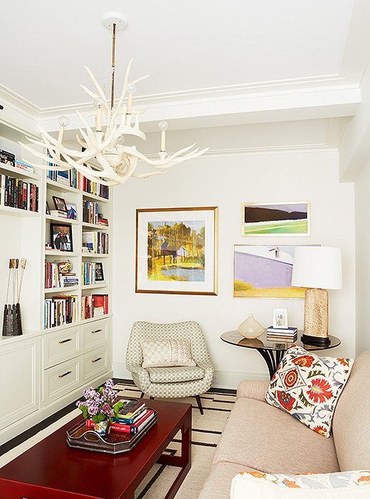 A narrow space reaches its full potential with the addition of an inviting seating area crowned by an antler chandelier. (Find a similar chandelier here.)
