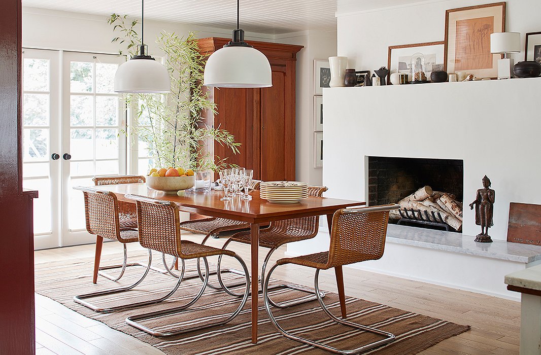 Chairs by Mies van der Rohe surround a midcentury table. “I think my favorite spot in the house is the dining room,” says Laura. “It has a beautiful view of the garden, which lends it a meditative quality.” French doors installed by Cloud allow for plenty of light—a far cry from the dim space it once was. 
