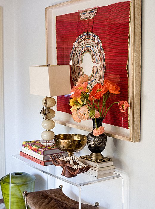 A woven huipil Paula found on a trip to Mexico was framed and hung above an acrylic console.
