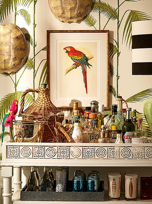 Bar cart essentials such as a silver champagne bucket were given whimsical new life with the addition of a faux parrot and a pair of tortoise shells. “Accent what you already have,” Michelle suggests. “All you need are a few finishing touches to create a cohesive theme.” 
