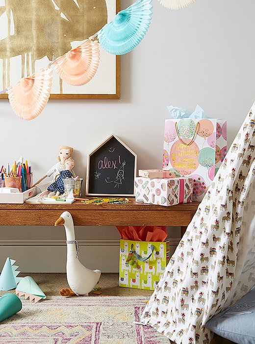 A wooden bench becomes a kid-height craft station with the addition of a chalkboard, sheets of paper, and jars of colored pencils. 
