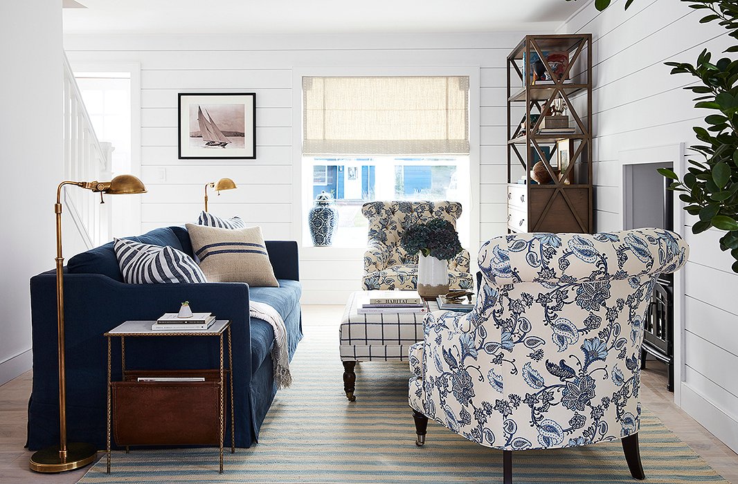 Brass pharmacy lamps by Ralph Lauren Home flank a Brownstone sofa in indigo linen. “Will was drawn to very classic yet masculine pieces,” says Sally. Patterned chairs by Barclay Butera soften the look, and an ottoman by Miles Talbott serves as extra seating when neighbors pop by.
