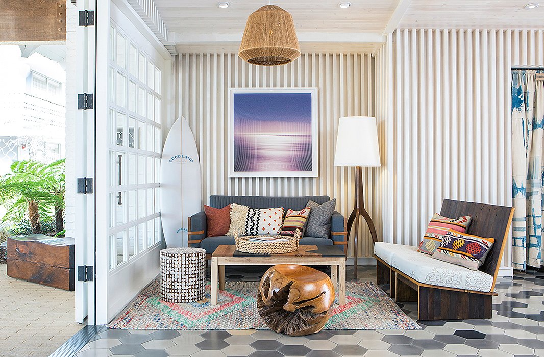 More surf references in a cozy corner of the lobby—plus a medley of tribal textiles and sculptural wood furnishings. The Manhattan Hanging Pendant is identical to the one above; the Linden Floor Lamp matches the one standing in the corner . Photo courtesy of The Goodland.
