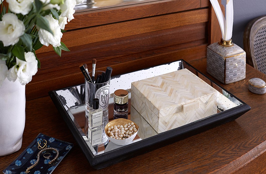 A mirrored tray corrals the candle vessel that holds Ari’s makeup and a mini catchall in which she stashes jewelry. The horn box holds other accessories and keepsakes.
